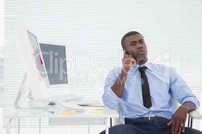 Businessman sitting at his desk on the phone