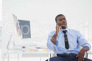 Businessman sitting at his desk on the phone