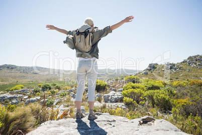 Hiker standing at the summit with her arms out