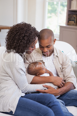 Happy parents spending time with baby on the couch