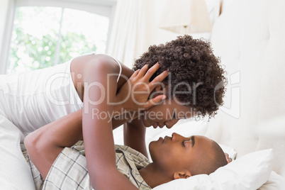 Intimate couple cuddling lying on their bed