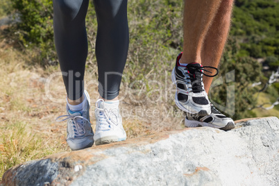 Fit couple jogging up mountain trail