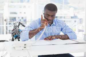 Smiling businessman on the phone at desk