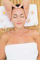 Smiling brunette enjoying a head massage