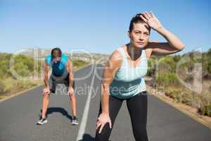 Fit couple jogging on the open road together
