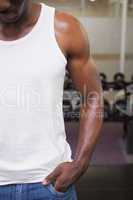 Mid section of a cropped muscular man in gym