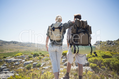 Hiking couple standing on mountain terrain