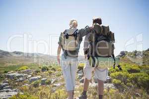 Hiking couple standing on mountain terrain