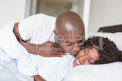 Happy couple lying in bed together