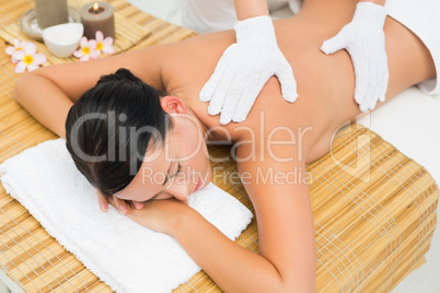 Peaceful brunette enjoying an exfoliating back massage