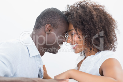Couple sitting on couch together smiling Couple sitting on couch together smiling