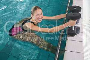 Fit blonde working out with foam dumbbells
