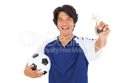 Football player in blue holding winners trophy