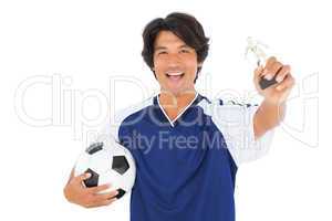Football player in blue holding winners trophy