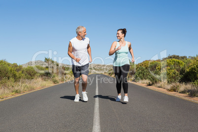 Fit couple running on the open road together