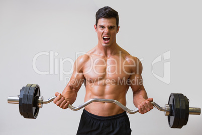 Shirtless muscular man lifting barbell