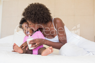 Happy parents with baby girl on their bed