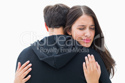 Unhappy brunette hugging her boyfriend