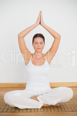 Peaceful brunette sitting and meditating in lotus pose