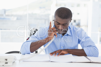 Serious businessman on the phone at desk