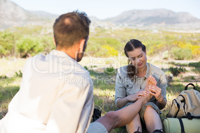Caring girlfriend giving her boyfriend a foot rub on a hike