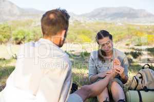 Caring girlfriend giving her boyfriend a foot rub on a hike