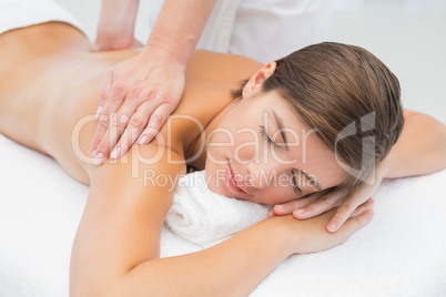 Attractive young woman receiving back massage at spa center