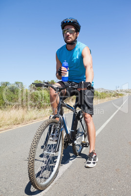 Handsome cyclist taking a break on his bike