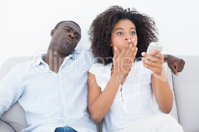 Couple sitting on couch together watching tv