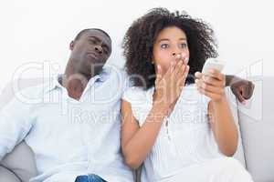 Couple sitting on couch together watching tv