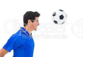 Football player in blue heading ball