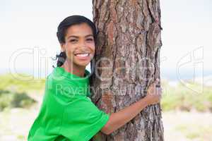 Pretty environmental activist hugging tree
