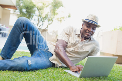 Handsome man relaxing in his garden using laptop