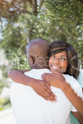 Happy couple hugging each other in garden