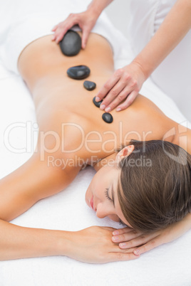 Beautiful woman receiving stone massage at spa center