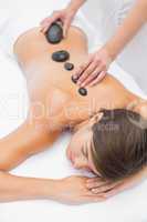 Beautiful woman receiving stone massage at spa center