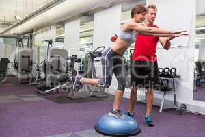 Personal trainer with client on bosu ball