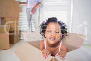 Cute daughter sitting in moving box