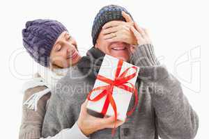 Happy mature woman hiding gift from partner