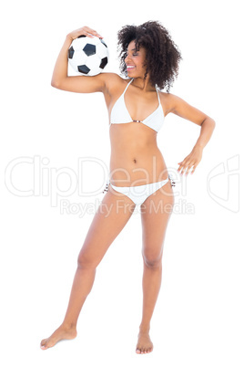 Happy fit girl in white bikini holding football