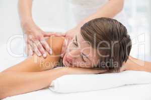 Attractive woman receiving shoulder massage at spa center