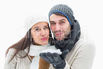 Attractive young couple in warm clothes blowing