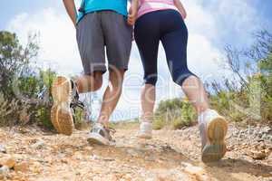 Fit couple running up mountain trail