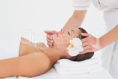 Attractive young woman receiving head massage at spa center