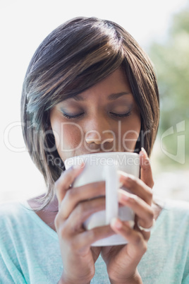 Pretty woman sitting outside having coffee