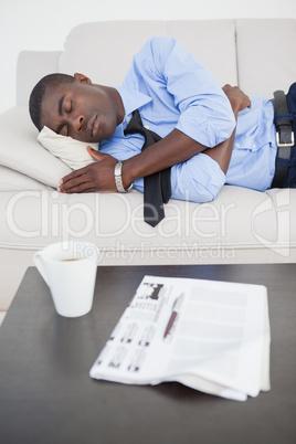 Tired businessman sleeping on the sofa