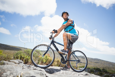 Fit man cycling on rocky terrain