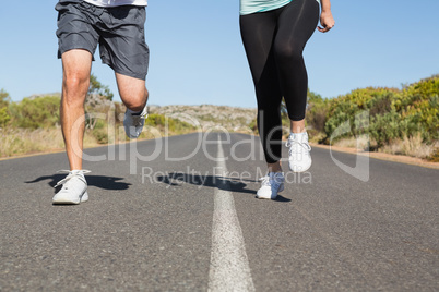 Fit couple running on the open road together