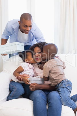 Happy family on the couch giving mother presents