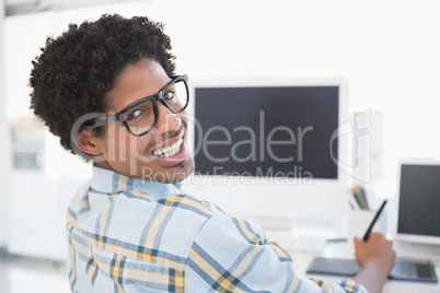 Young casual businessman smiling at camera